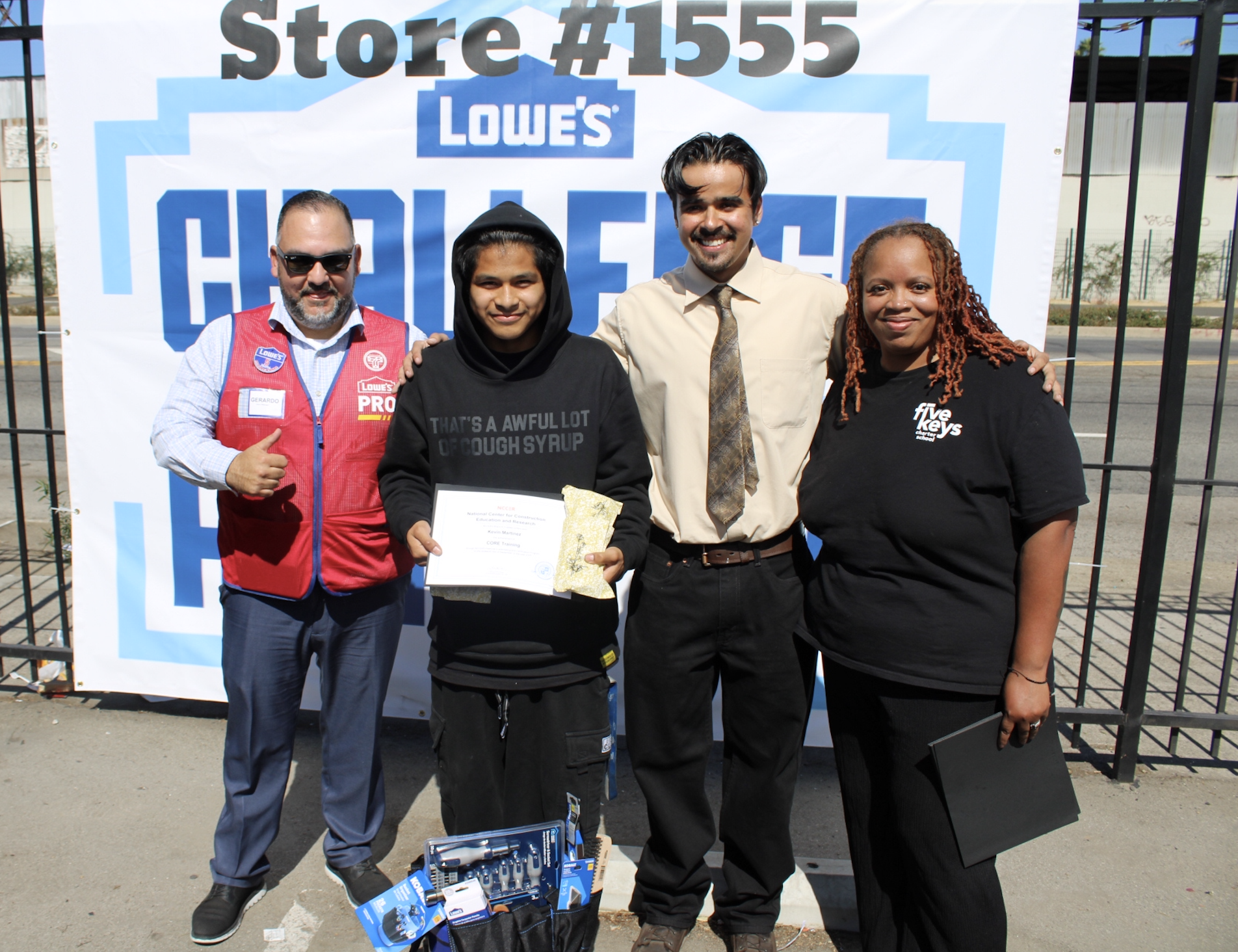 4 people standing in front of a sign